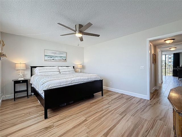 1581 Gulf Blvd Unit 102N, Clearwater Beach, FL 33767 - bedroom with light wood-type flooring, a textured ceiling, and a ceiling fan