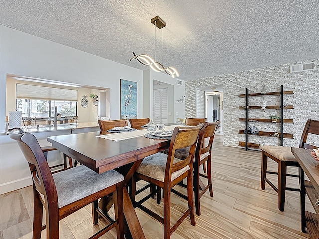 1581 Gulf Blvd Unit 102N, Clearwater Beach, FL 33767 - dining area with a textured ceiling and light wood-style flooring
