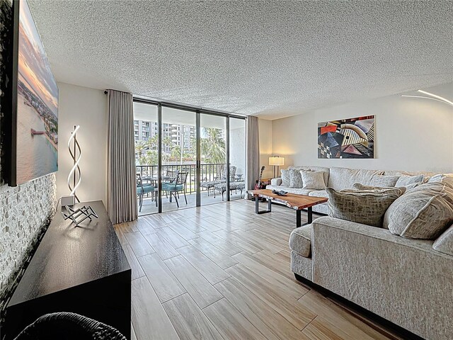1581 Gulf Blvd Unit 102N, Clearwater Beach, FL 33767 - living area with a wall of windows, a textured ceiling, and wood finished floors
