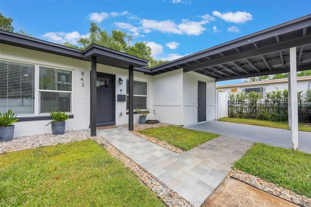 entrance to property featuring fence and a yard