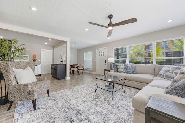 living room with ceiling fan, recessed lighting, and light wood-style floors