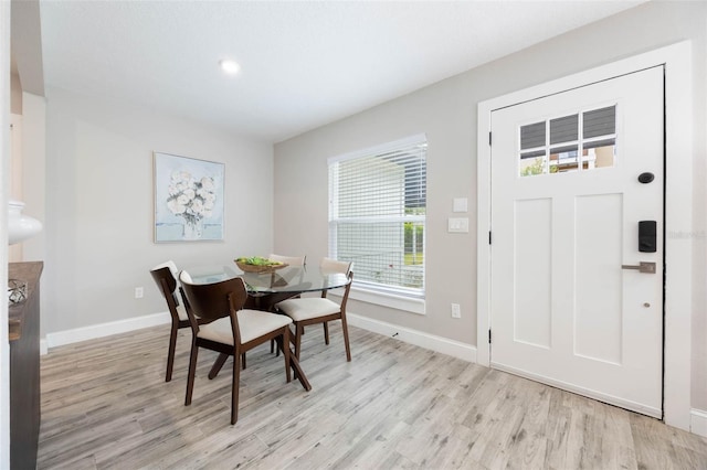 dining area with baseboards and light wood-style floors