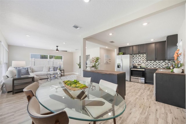 dining area with recessed lighting, a textured ceiling, light wood-style floors, visible vents, and a ceiling fan