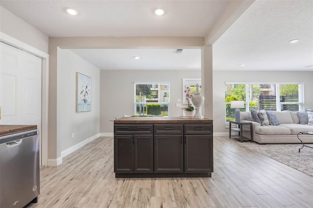 kitchen with dishwasher, wooden counters, a healthy amount of sunlight, and light wood finished floors