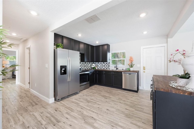 kitchen featuring a sink, wooden counters, light wood-style flooring, stainless steel appliances, and visible vents