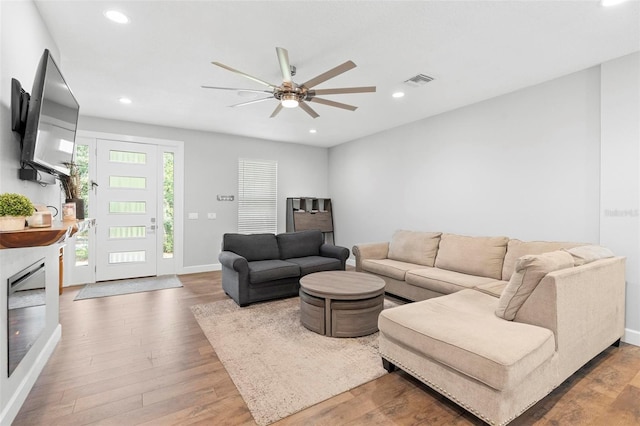 living room with visible vents, baseboards, ceiling fan, wood finished floors, and recessed lighting