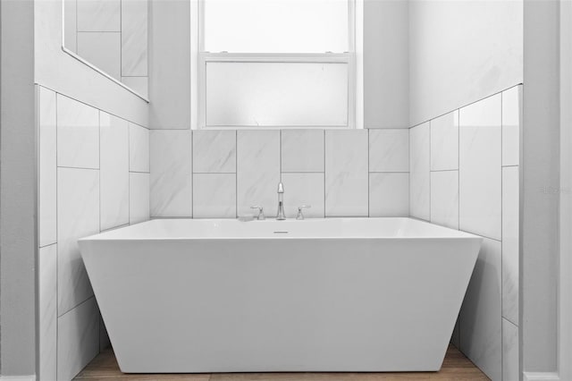 full bathroom with tile walls and a freestanding tub