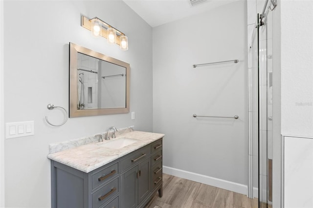 bathroom with baseboards, curtained shower, wood finished floors, and vanity