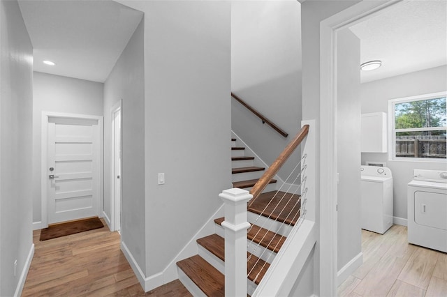 stairway featuring recessed lighting, washing machine and dryer, baseboards, and wood finished floors