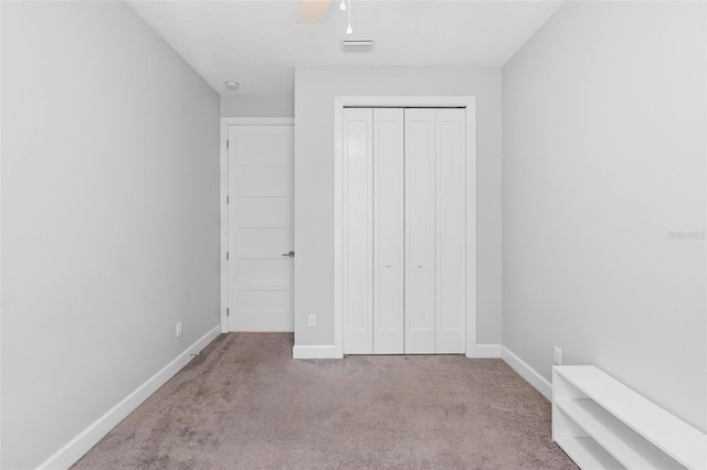 unfurnished bedroom featuring baseboards, visible vents, a closet, and carpet floors