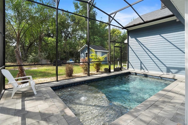 pool featuring a lanai, an outbuilding, and a patio
