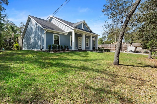 view of front of home with a front lawn and fence