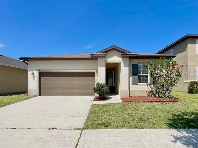 254 Alford Dr, Davenport, FL 33896 - view of front of home with stucco siding, concrete driveway, a front lawn, and a garage