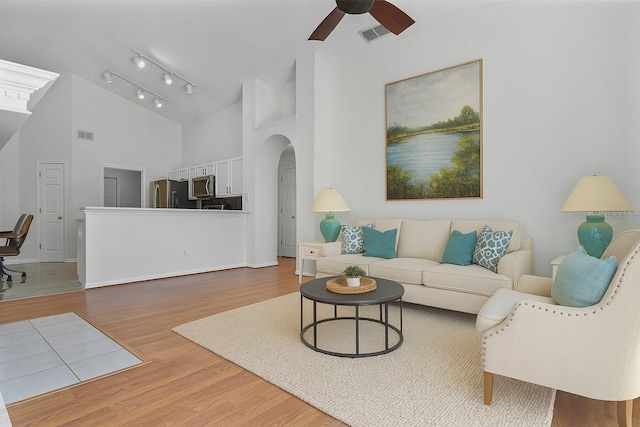 7606 Fordham Creek Ln, Orlando, FL 32818 - living area with ceiling fan, wood finished floors, high vaulted ceiling, and arched walkways