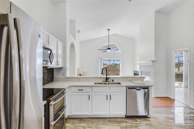 7606 Fordham Creek Ln, Orlando, FL 32818 - kitchen featuring appliances with stainless steel finishes, ceiling fan, white cabinetry, a peninsula, and light countertops