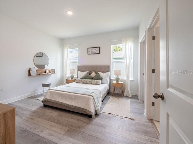 bedroom with baseboards, light wood finished floors, and recessed lighting