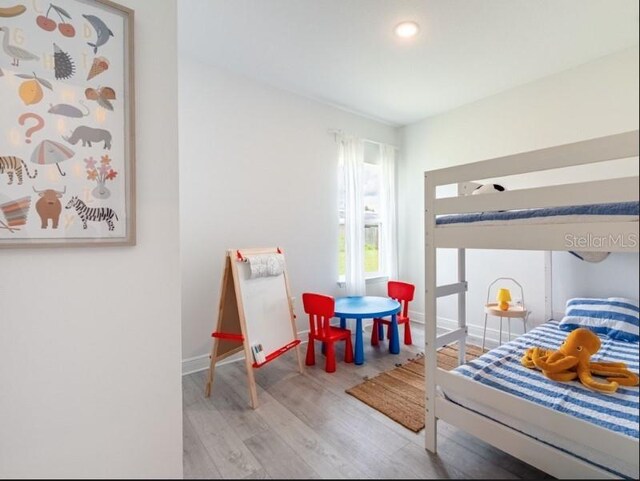 bedroom featuring baseboards and wood finished floors