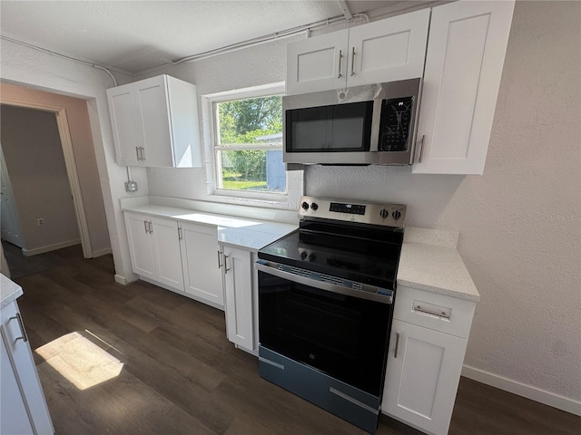 kitchen featuring dark wood-type flooring, stainless steel microwave, electric range oven, and white cabinets