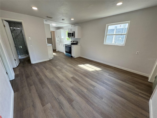 unfurnished living room with a textured ceiling, baseboards, dark wood-style floors, and recessed lighting