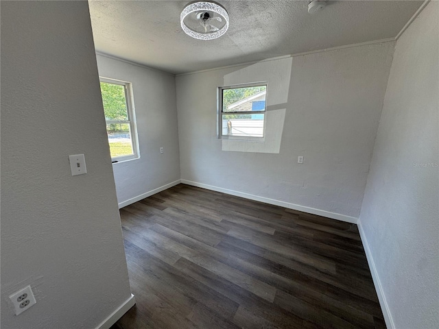 unfurnished room with a textured wall, baseboards, a textured ceiling, and dark wood finished floors