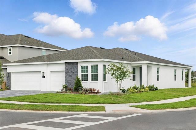 2152 Rock Maple Bnd, Kissimmee, FL 34746 - view of front of house with a garage, stucco siding, decorative driveway, a front yard, and a shingled roof