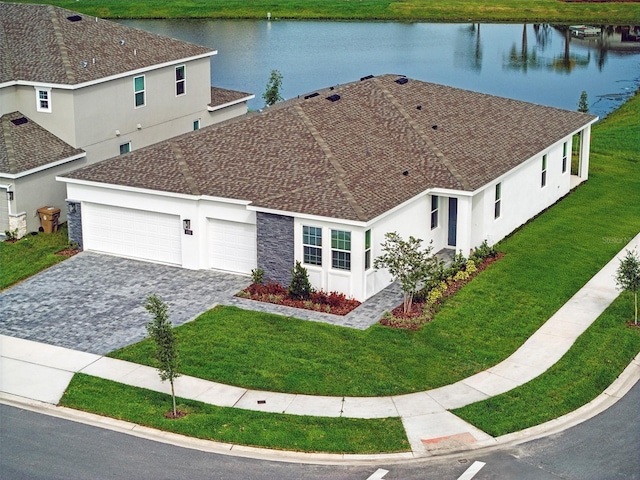 2152 Rock Maple Bnd, Kissimmee, FL 34746 - view of front of home with a water view, decorative driveway, stucco siding, and a garage