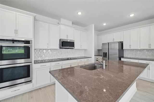 2152 Rock Maple Bnd, Kissimmee, FL 34746 - kitchen with stainless steel appliances, white cabinetry, decorative backsplash, light wood-style floors, and recessed lighting