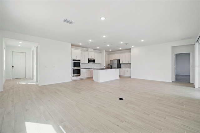 2152 Rock Maple Bnd, Kissimmee, FL 34746 - unfurnished living room with recessed lighting and light wood-style floors
