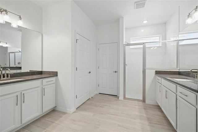 2152 Rock Maple Bnd, Kissimmee, FL 34746 - full bathroom featuring two vanities, a stall shower, and wood finished floors