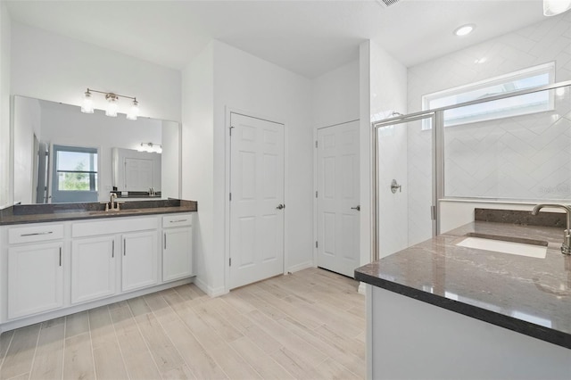2152 Rock Maple Bnd, Kissimmee, FL 34746 - full bathroom featuring two vanities, a stall shower, and wood finished floors