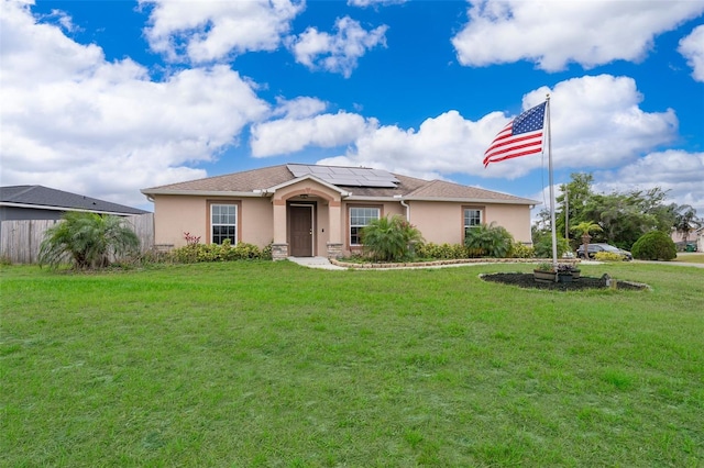 single story home with stucco siding, fence, a front lawn, and solar panels