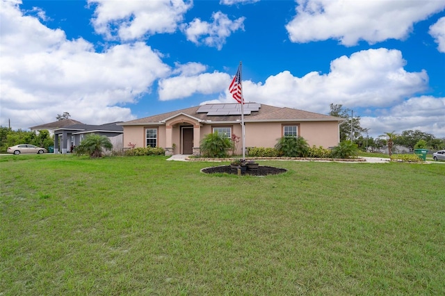 view of front of house featuring roof mounted solar panels, stucco siding, and a front lawn