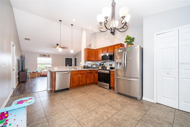 kitchen with visible vents, light countertops, appliances with stainless steel finishes, a peninsula, and brown cabinets