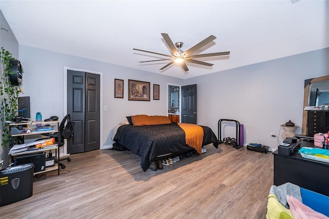 bedroom featuring ceiling fan, light wood-style floors, and baseboards