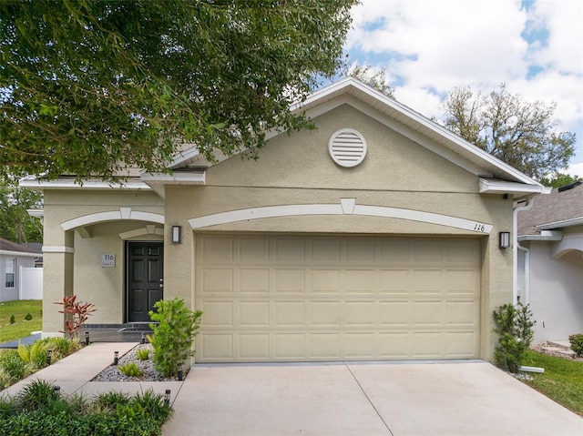 view of front of property featuring concrete driveway, a garage, and stucco siding