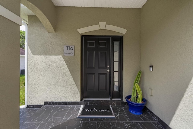 doorway to property featuring stucco siding