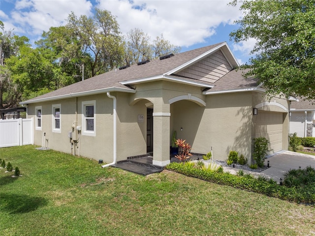 ranch-style house featuring a garage, a front yard, fence, and stucco siding