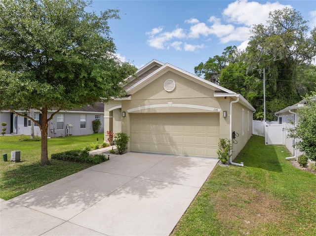 view of front of house featuring stucco siding, driveway, an attached garage, a front lawn, and a gate