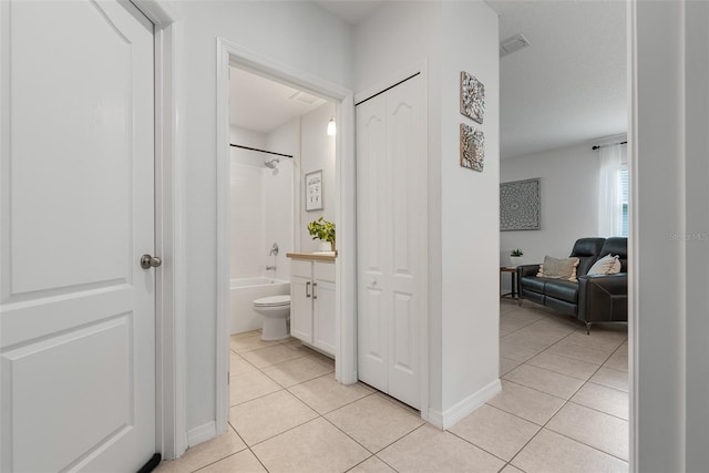 corridor featuring light tile patterned floors and visible vents