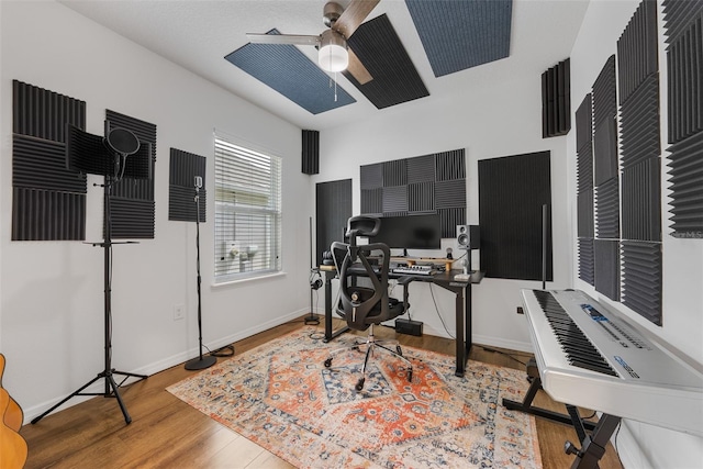 office space featuring baseboards, a ceiling fan, and wood finished floors