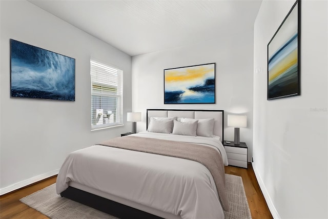 bedroom with wood finished floors and baseboards