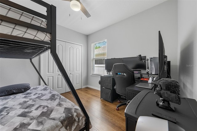bedroom featuring ceiling fan, a closet, baseboards, and wood finished floors
