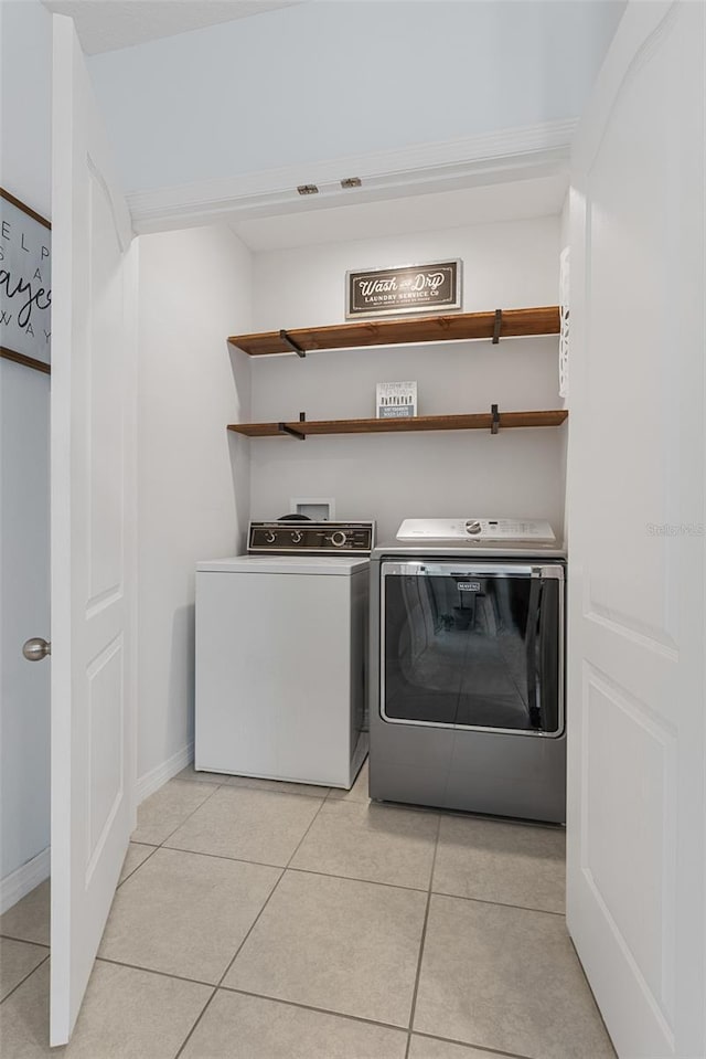 laundry room featuring independent washer and dryer, laundry area, light tile patterned floors, and baseboards