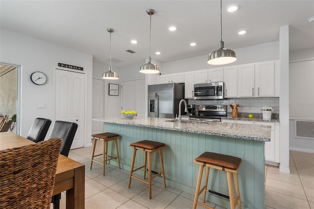 kitchen with light tile patterned floors, white cabinetry, visible vents, appliances with stainless steel finishes, and a sink