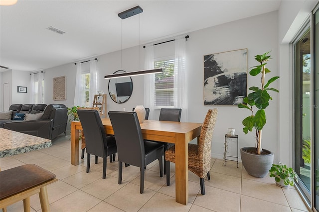 dining space featuring visible vents, light tile patterned floors, and a healthy amount of sunlight