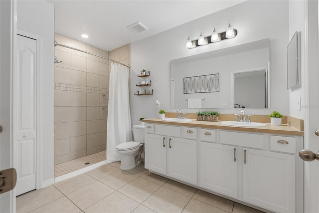 bathroom with a sink, visible vents, a tile shower, and tile patterned floors