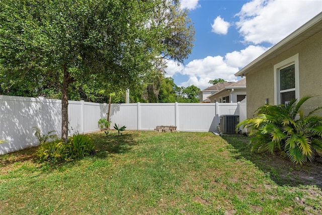 view of yard featuring a fenced backyard and central AC