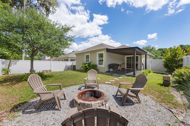 back of house featuring a patio, stucco siding, a fire pit, a fenced backyard, and a lawn