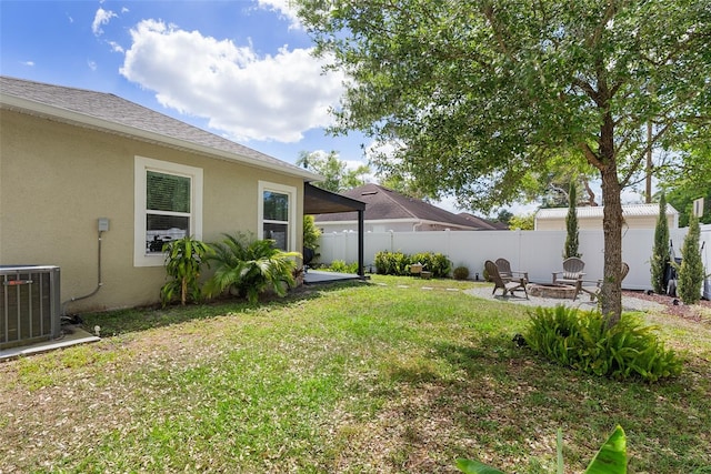 view of yard with central AC unit, fence, a fire pit, and a patio
