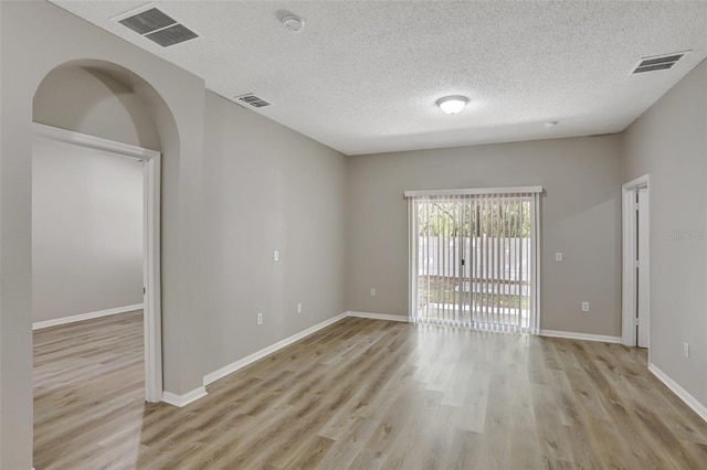 empty room featuring light wood-type flooring, baseboards, and visible vents